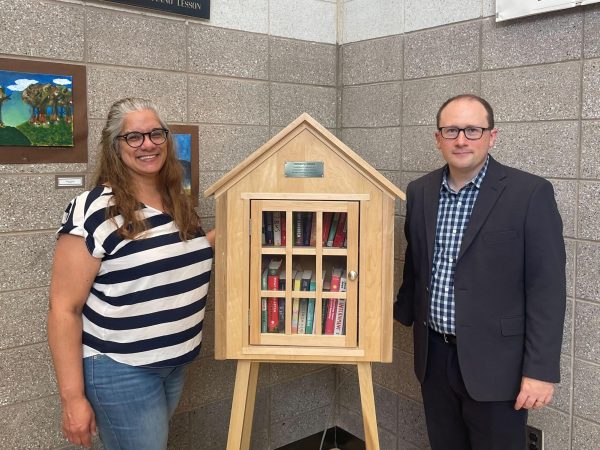 Ms. Laverde and Mr. Sweeney stand with the Little Free Library, called Tophers Corner, donated by retired English teacher Helen Rizzuto.