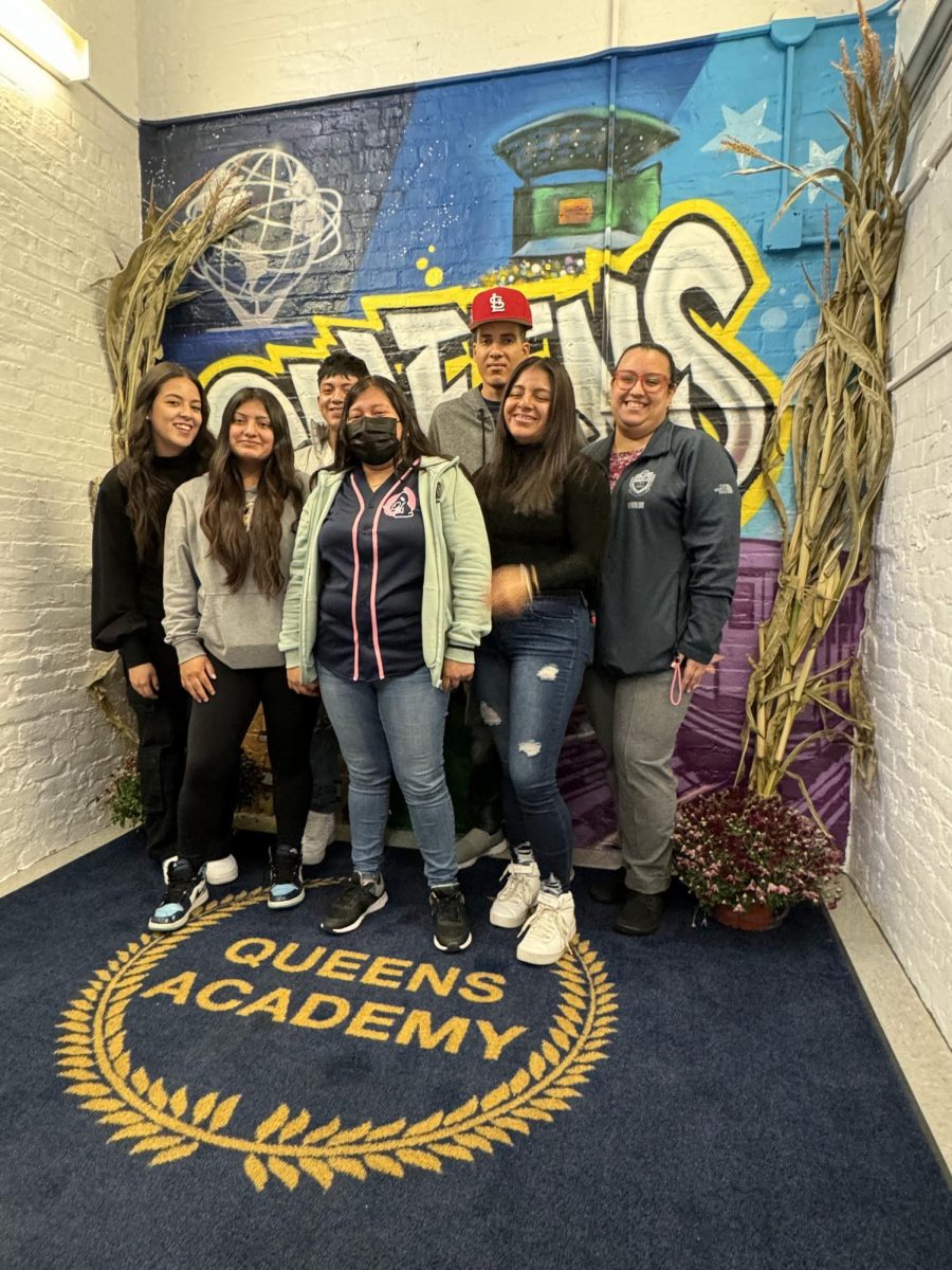 Newcomer students pose with their teacher at Queens Academy High School
