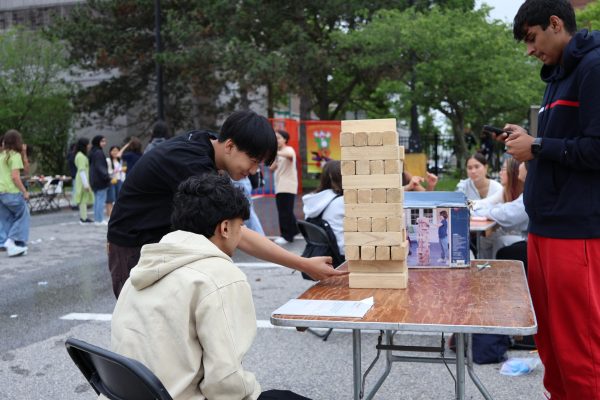 Students playing giant Jenga at an activity station during Keepers Day