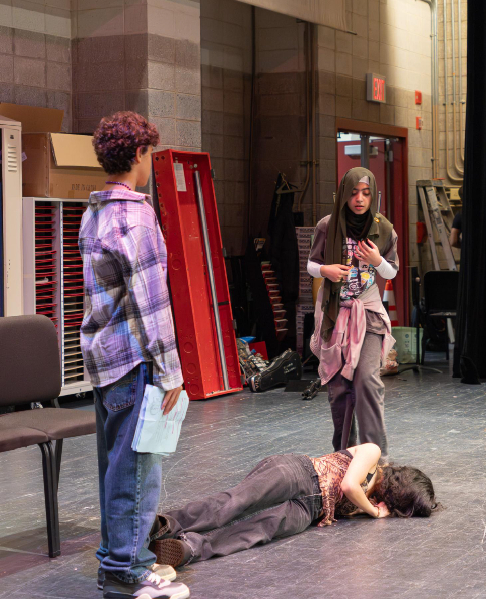 Students act out a scene on stage.