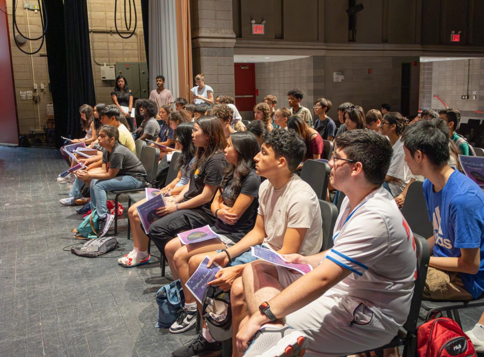 Students watch their peers perform.