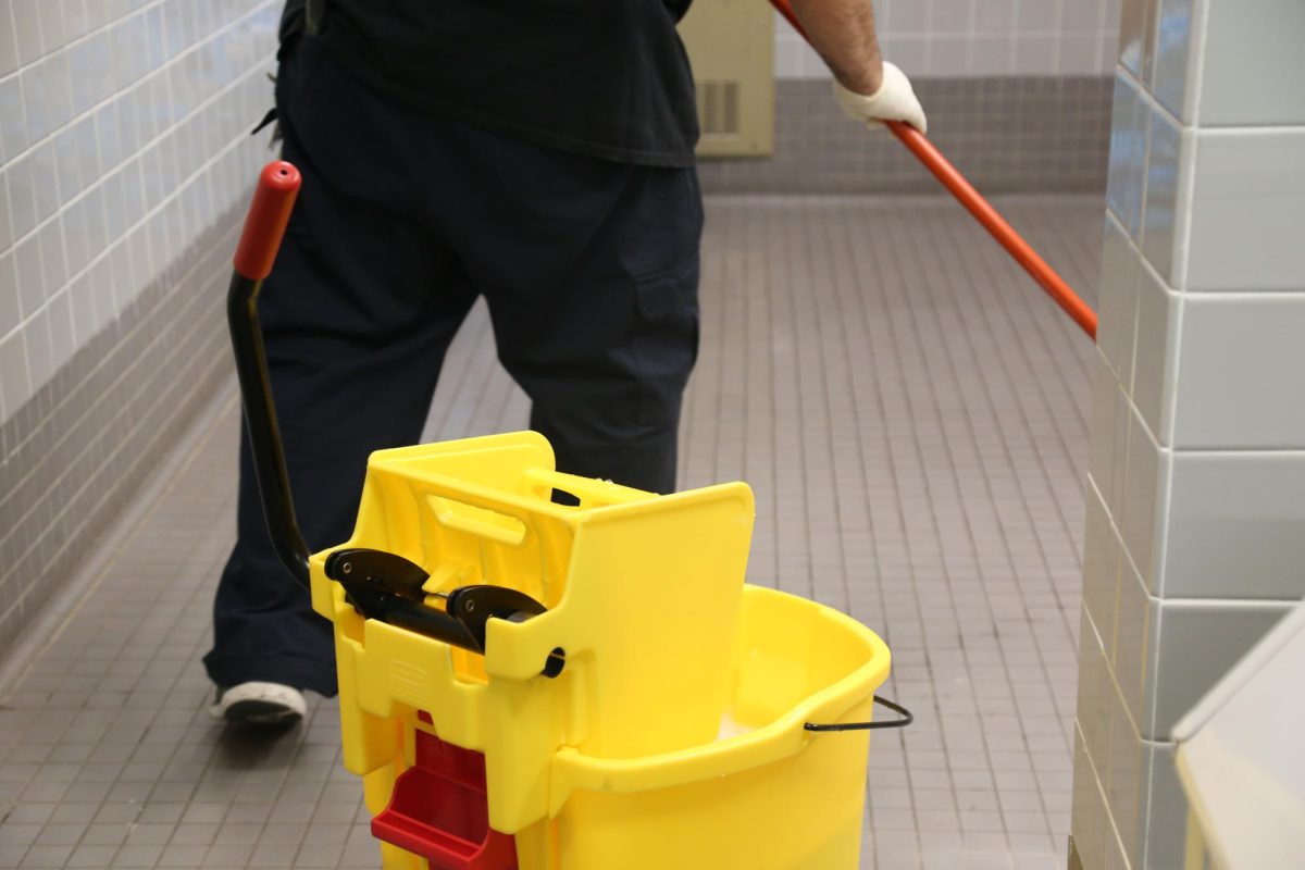 A custodian works to clean a bathroom at THHS. Custodians worked all summer to reopen the building for the fall term.