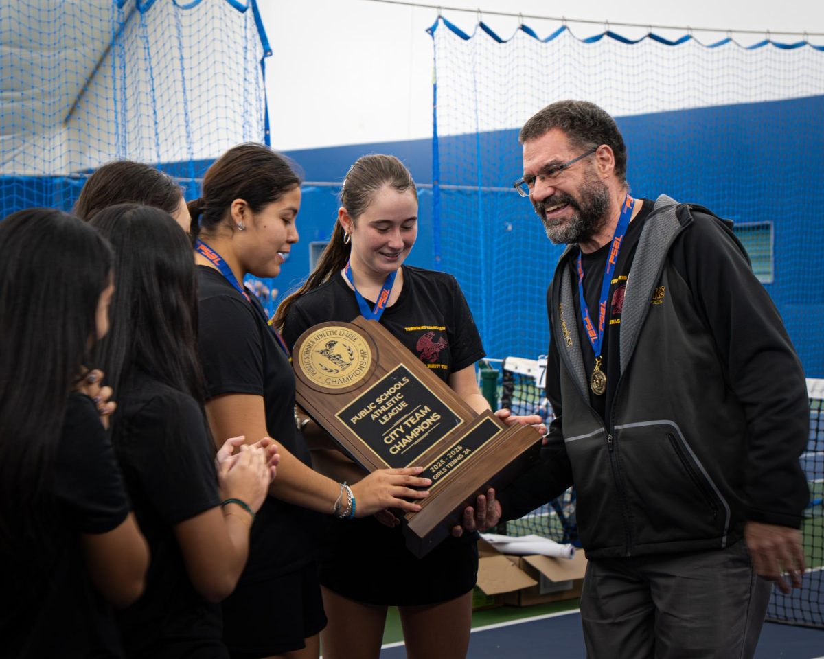 Girls varsity tennis Coach Dr. Mazza handing the Girls Varsity Tennis team the city championship plaque after winning the championship on November 10.