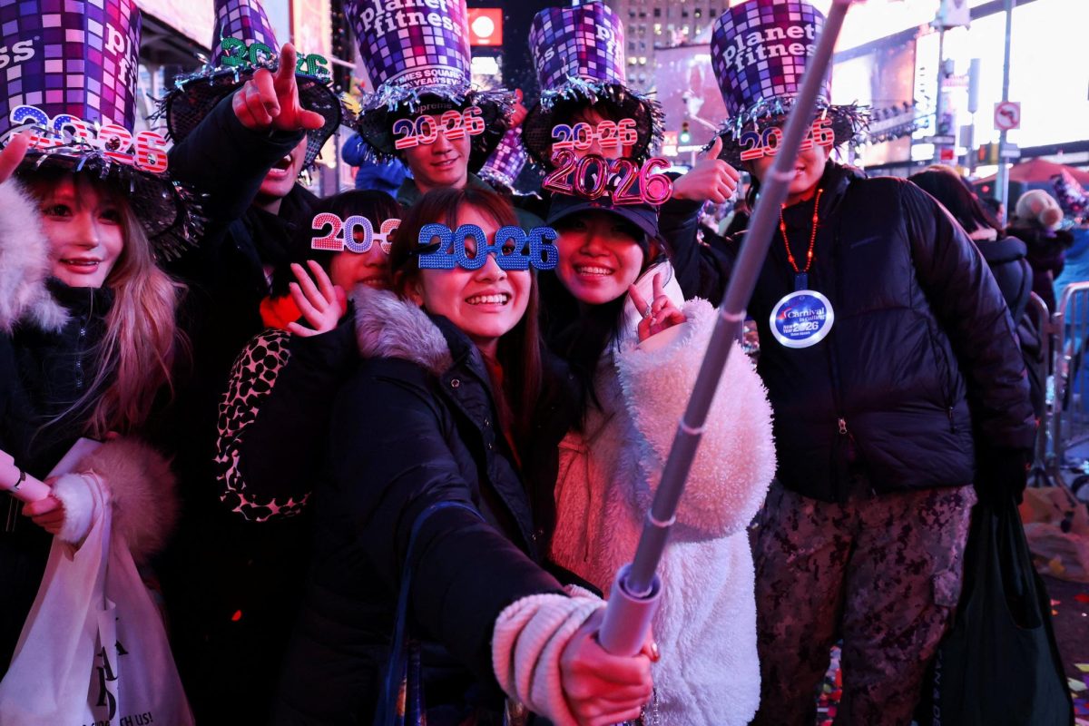 People pose with hats and 2026 glasses after the ball drop at Times Square during New Year's celebrations in New York City, U.S., January 1, 2026. REUTERS/Kylie Cooper