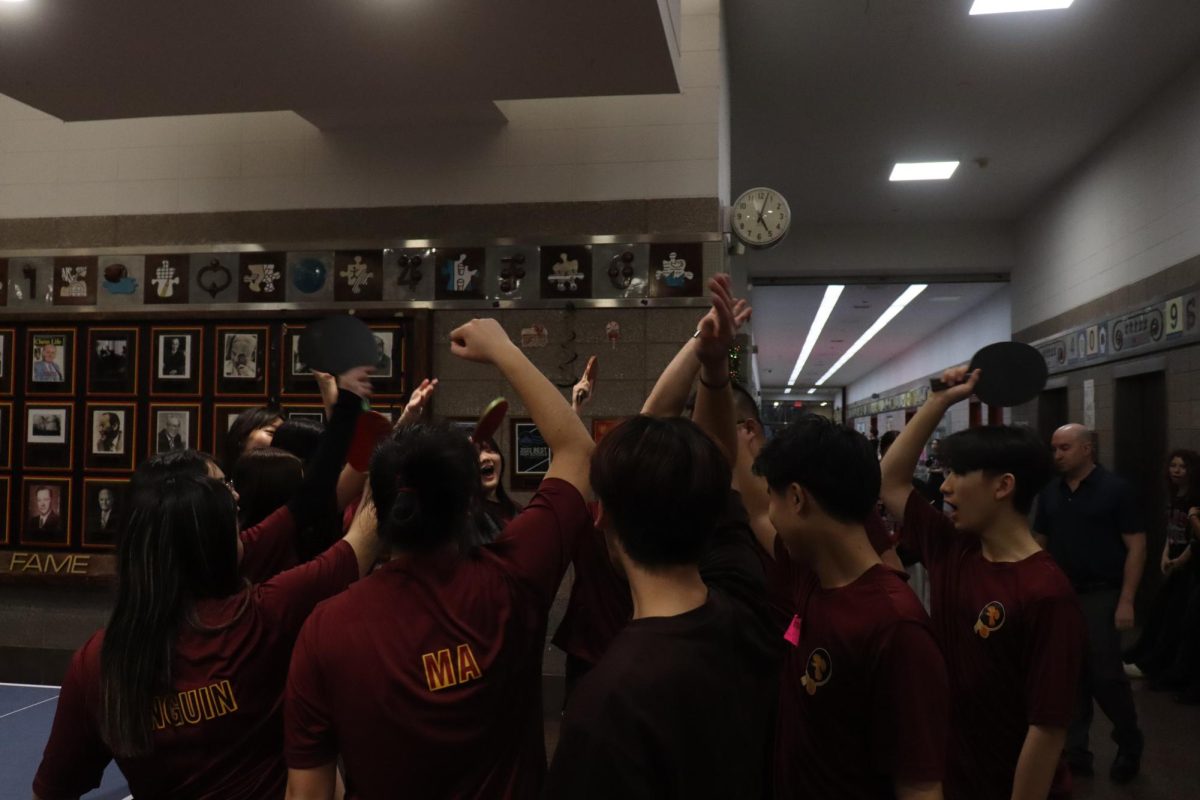 The girls varsity table tennis team huddled before the game against Francis Lewis High School on January 8. The team is in third place in the Queens Division II with a standing of 5-3.