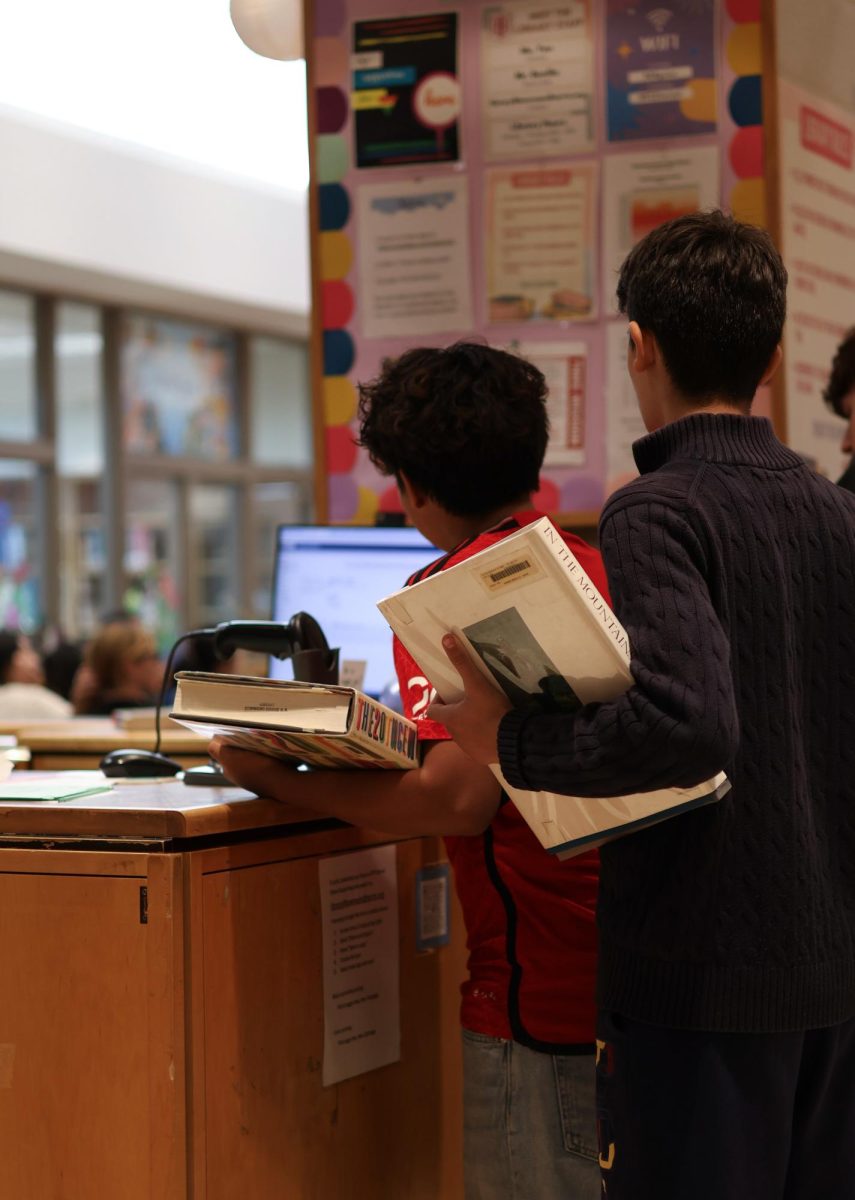 Students checking out books in the Townsend Harris library. 