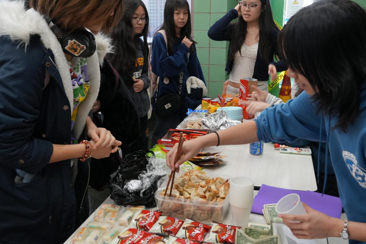 The girls varsity fencing team selling food during Asian Fest. 
