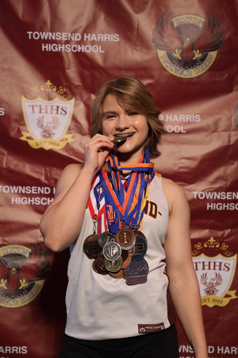 Junior Natalia Piszczatowski posing with her track and field medals for a team media day.