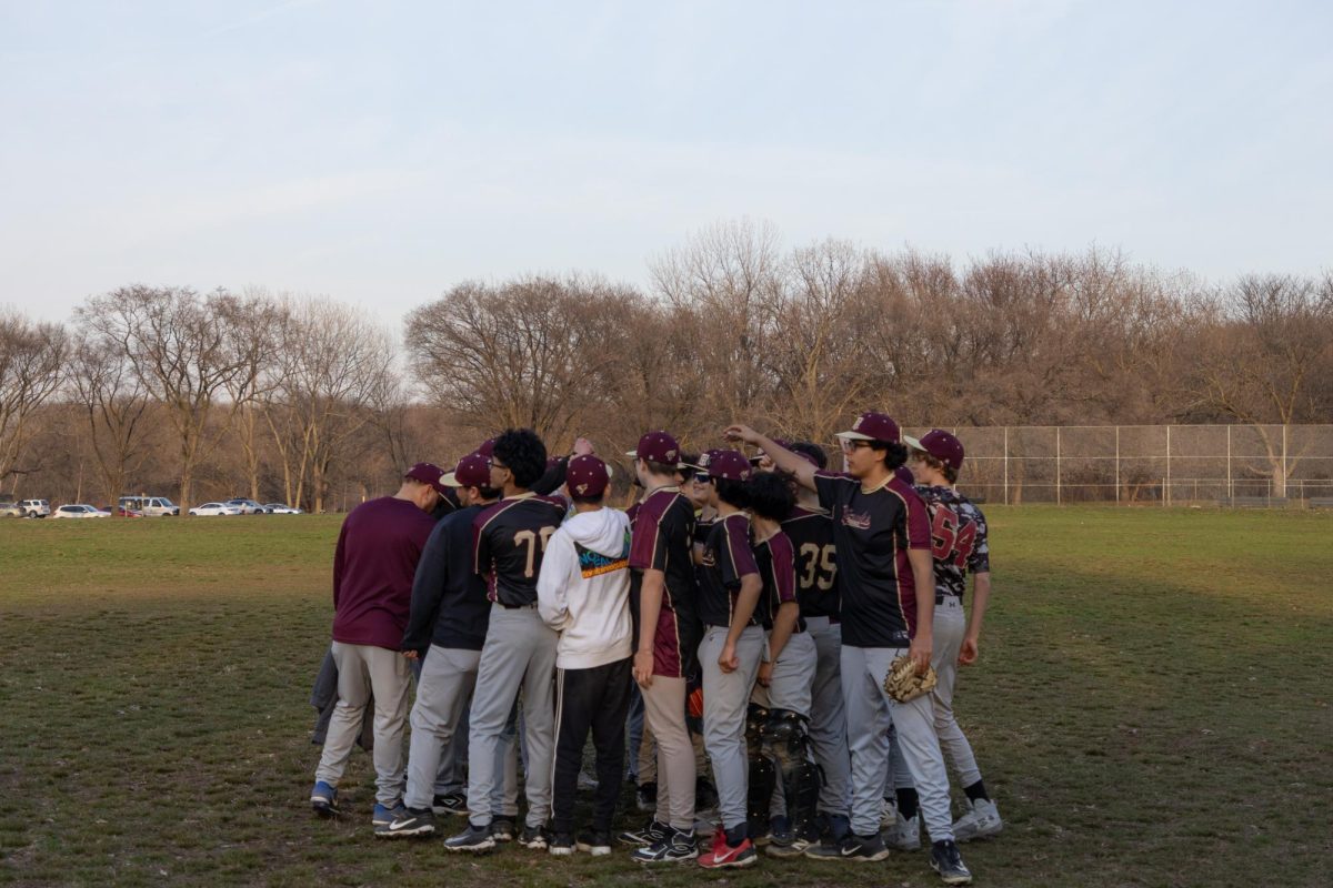 The boys varsity baseball team huddling during a game.