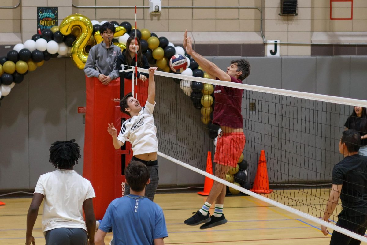English teacher Mr. McDonough blocking the volleyball after an attempt to spike it during the 2026 students vs staff volleyball game. 