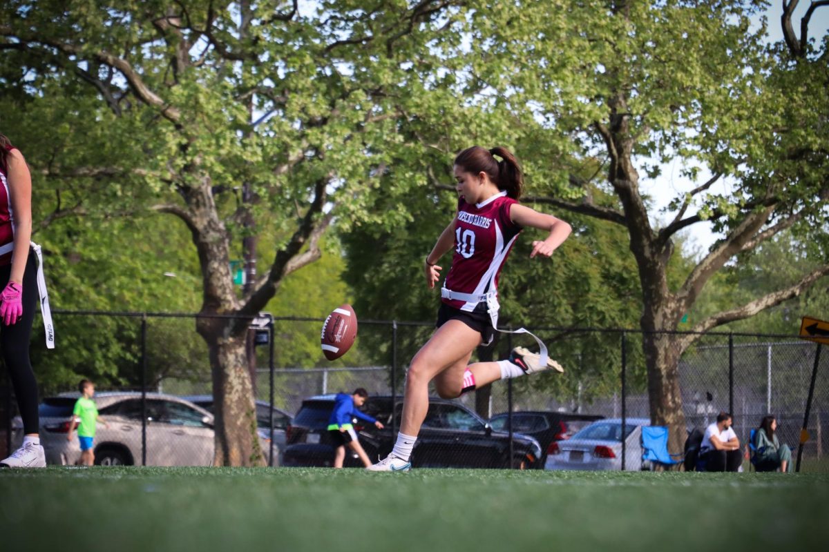 Junior captain Keira Legaspi kicking the football during the girls varsity flag football game against Springfield Gardens on May 7. The team earned a 36-6 victory, marking the end of its regular season. The team will be moving on into the playoffs, with its Round 2 playoff game on May 19. 