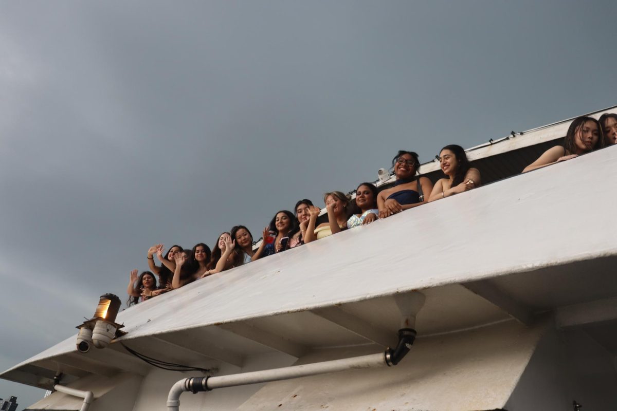 Juniors waving over the balcony from the third floor of the Skyline Princess cruise ship. 
