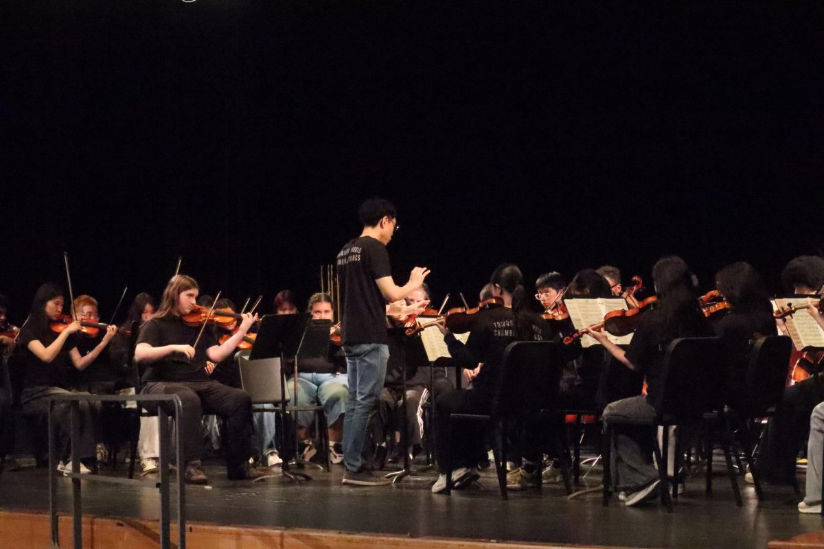 Music Teacher Christopher Lee leads strings during the second day of the Spring Concert.