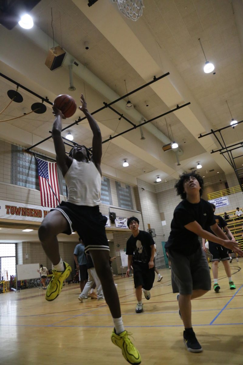 Junior Aidan Alleyne attempting a layup during the student basketball tournament and showcase
