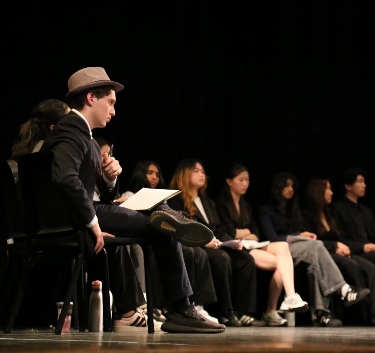 Incoming Student Union President junior Aki Bejamin and other SU candidates sitting on stage while waiting to give their speeches during the May 18 SU Debate. Aki said he plans to “burn [the SU] all down and start anew.”