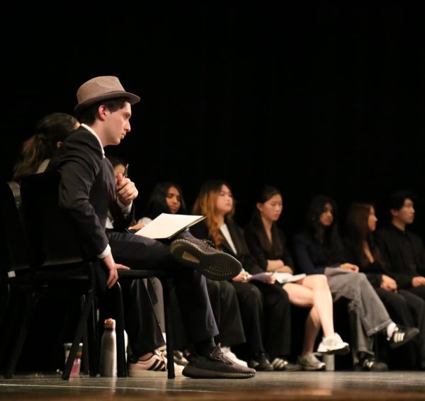 Incoming Student Union President junior Aki Bejamin and other SU candidates sitting on stage while waiting to give their speeches during the May 18 SU Debate. Aki said he plans to “burn [the SU] all down and start anew.”