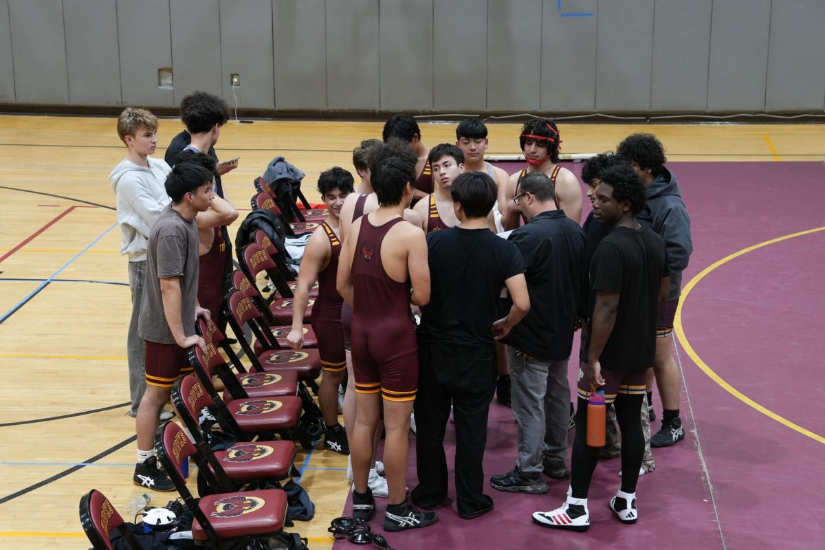 The boys varsity wrestling team huddling up during their match on January 1.