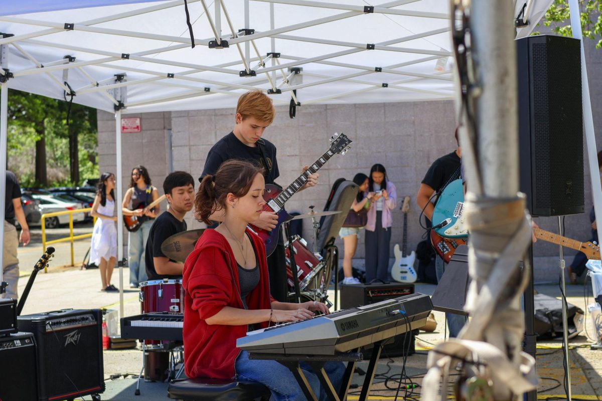 Rising juniors David Palacio, Julian Kenney, and Elena Clow playing the drums, guitar, and piano for a performance during Keepers Day, with rising junior Yuze Liu and rising senior Lukas Cooper on bass and guitar.