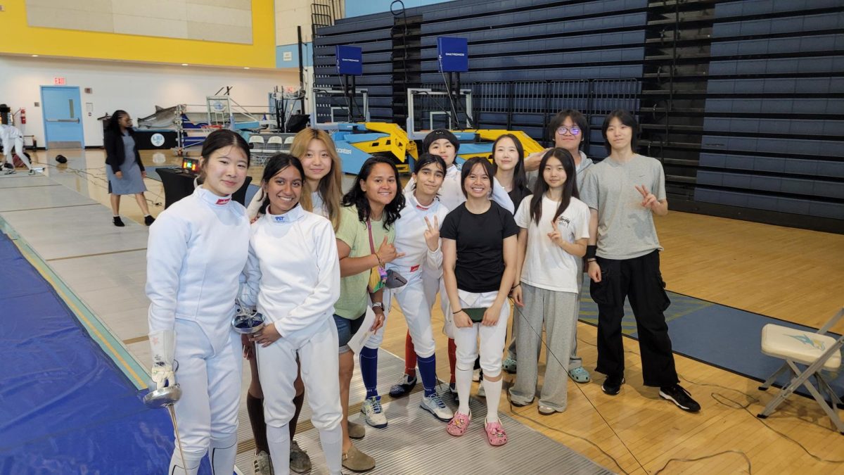On May 17, members of the girls fencing team and Coach Diane Ramirez pose following the epee team's win at PSAL fencing championships.