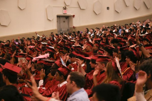Attendees of the graduation ceremony doing a “Fist to Five,” in memory of Mr. Seidel.